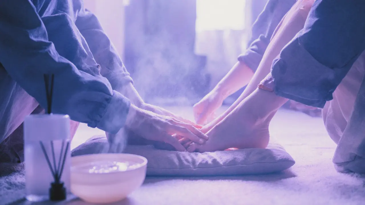 Two blindfolded people gently touching each other&#039;s feet during a quiet couples&#039; sensory session.